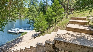 A concrete staircase leading down to a dock by a lake, surrounded by trees. - The Big Easy - Lakefront Only 1 mile to Popular Marina Beach! by Yosemite Region Resorts (Groveland)