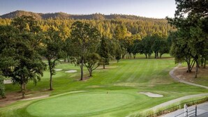 A golf course with well-maintained grass, sand bunkers, and trees. - Casa Del Lago - Only 200 Yards from the Beach by Yosemite Region Resorts (Groveland)