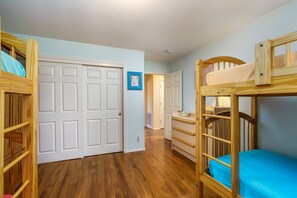 A room with bunk beds, a desk, and a chair. There are two doors and a hallway leading to another room. - Casa Del Lago - Only 200 Yards from the Beach by Yosemite Region Resorts (Groveland)
