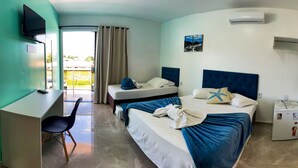 A hotel room with two beds, a desk, a chair, a TV, an air conditioner, and a refrigerator. - Pousada Mar de Luna (Penha)