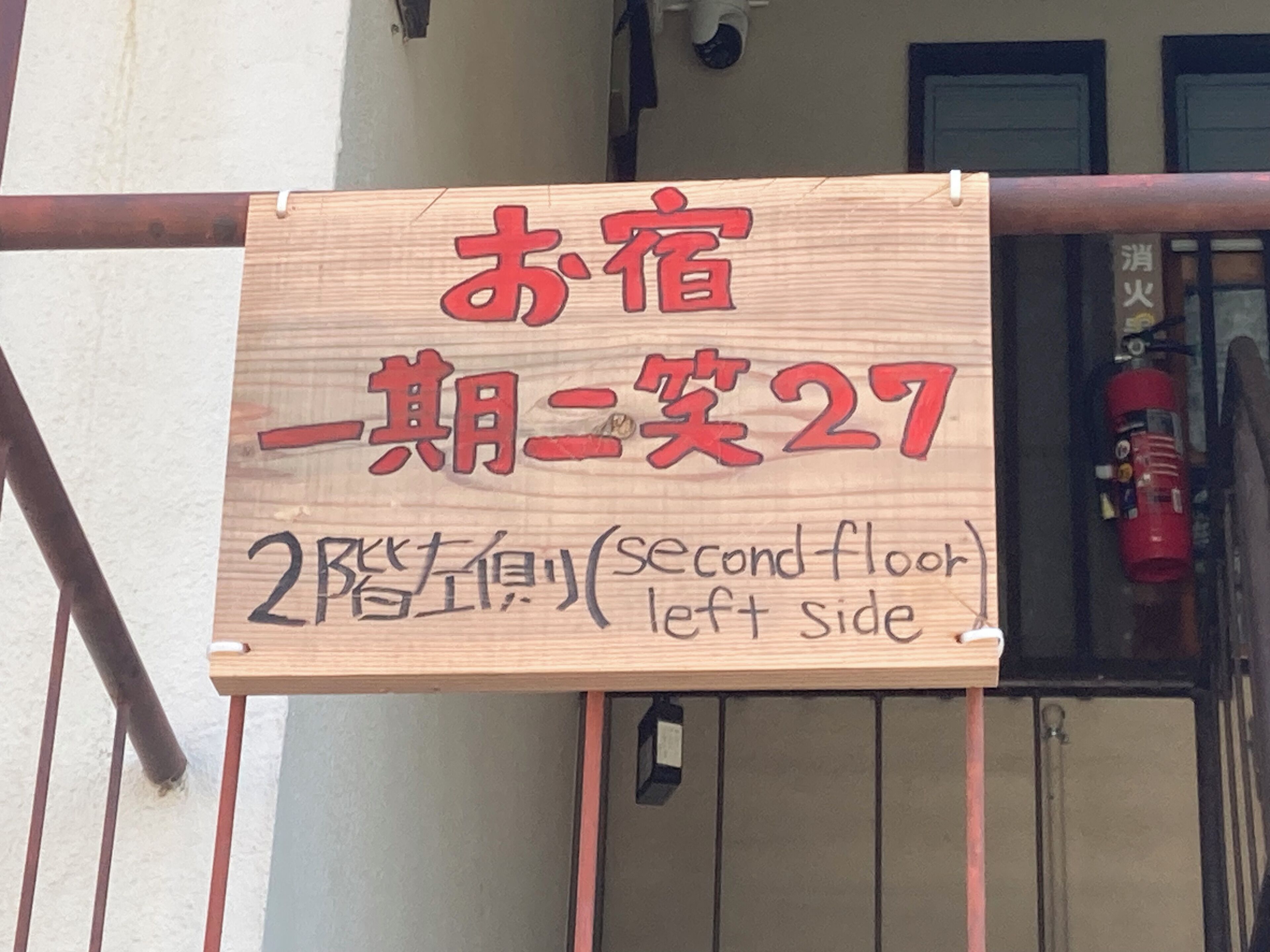 A wooden sign with Japanese text indicating a second-floor room on the left side.