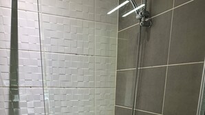 A shower area with tiled walls, a showerhead, and a toilet. - Studio 1 min walk from Châteaubriant castle with complimentary breakfast (Châteaubriant)