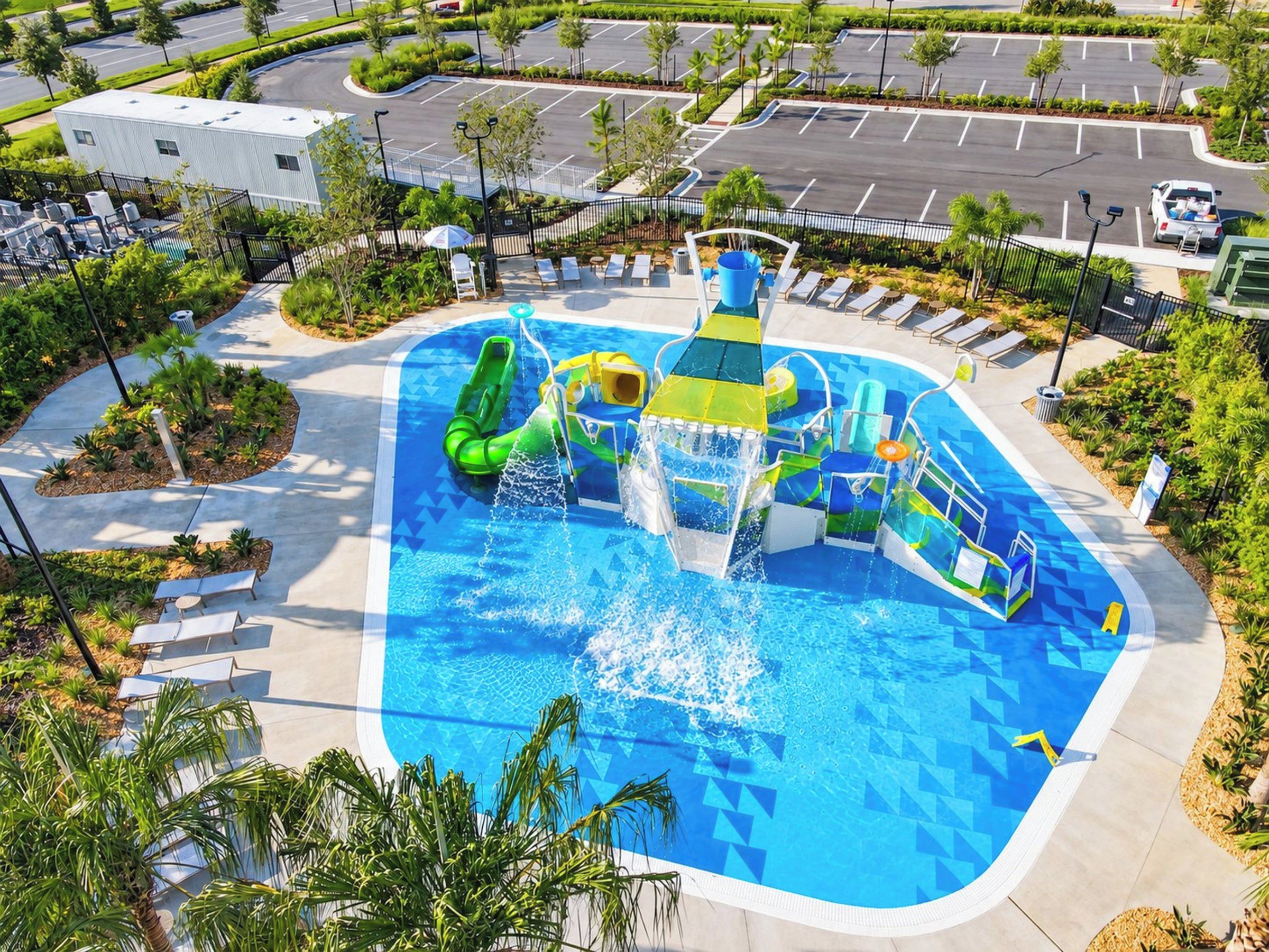 Parque acuático con una piscina grande, toboganes y una estructura de juegos.