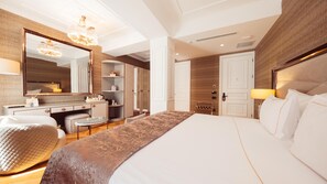 A modern hotel room with a large bed, a vanity with a mirror, a chandelier, and a view of the city. - De Reve Galata (Istanbul)