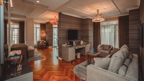 Una sala de estar moderna con un sofá, una mesa de centro, un televisor y un comedor con mesa y sillas.