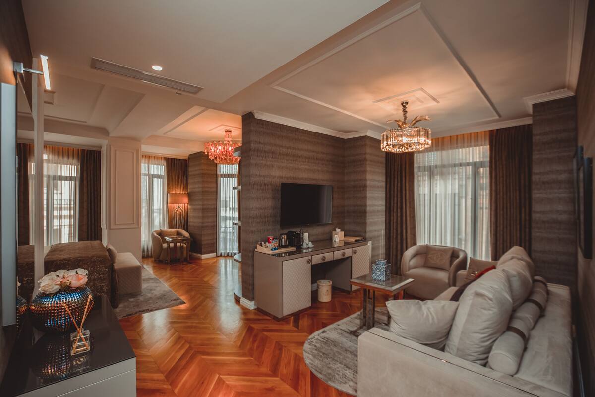 A modern living room with a sofa, a coffee table, a TV, and a dining area with a table and chairs.