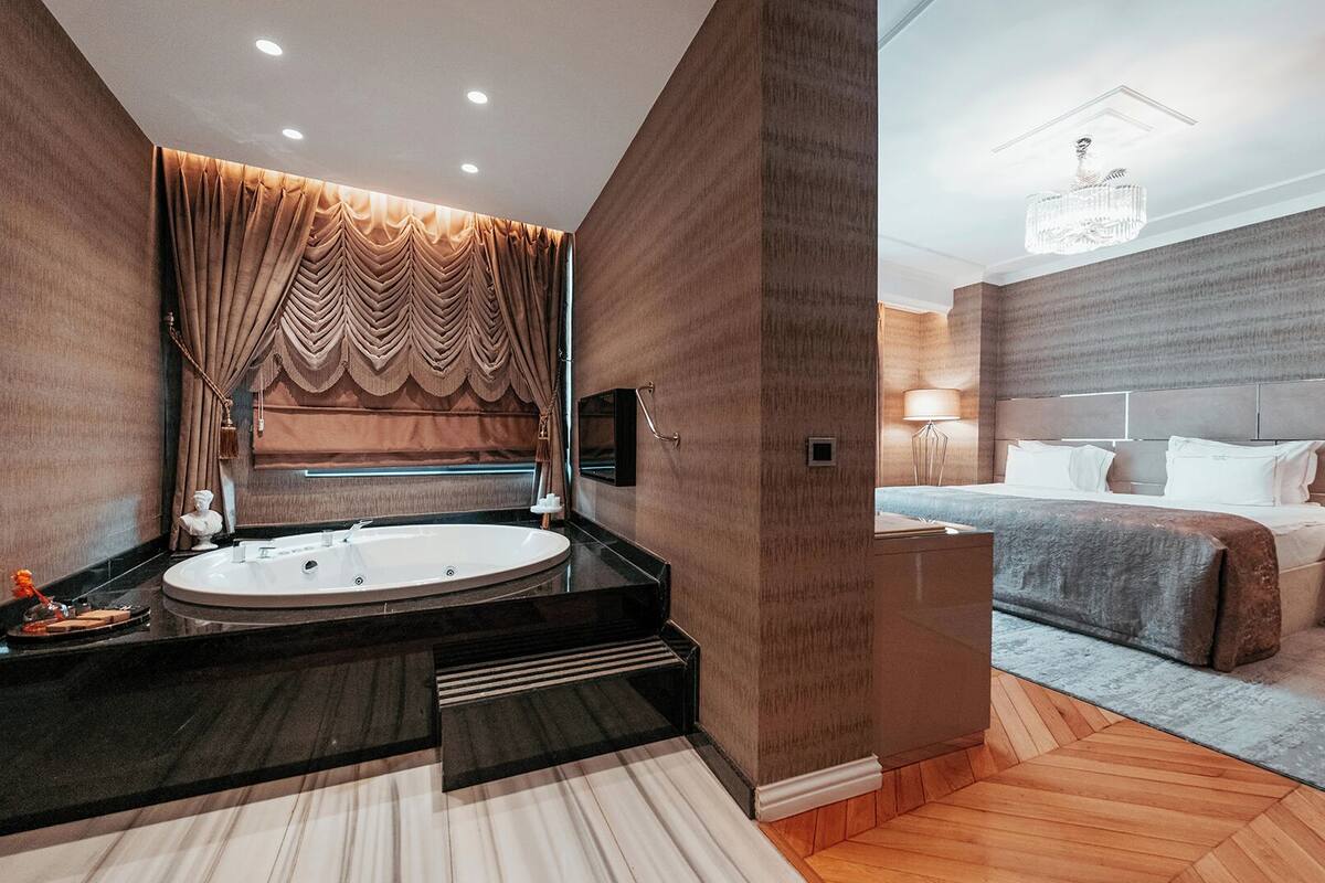 A modern bathroom with a freestanding bathtub, a vanity, and a large mirror.