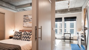 Une chambre d’hôtel moderne équipée d’un lit, d’un bureau et d’une kitchenette.