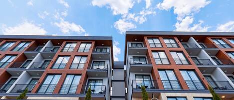 A modern multi-story building with balconies and large windows.