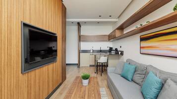A modern kitchen with wooden cabinetry, a built-in oven, and a dining area with a white chair.