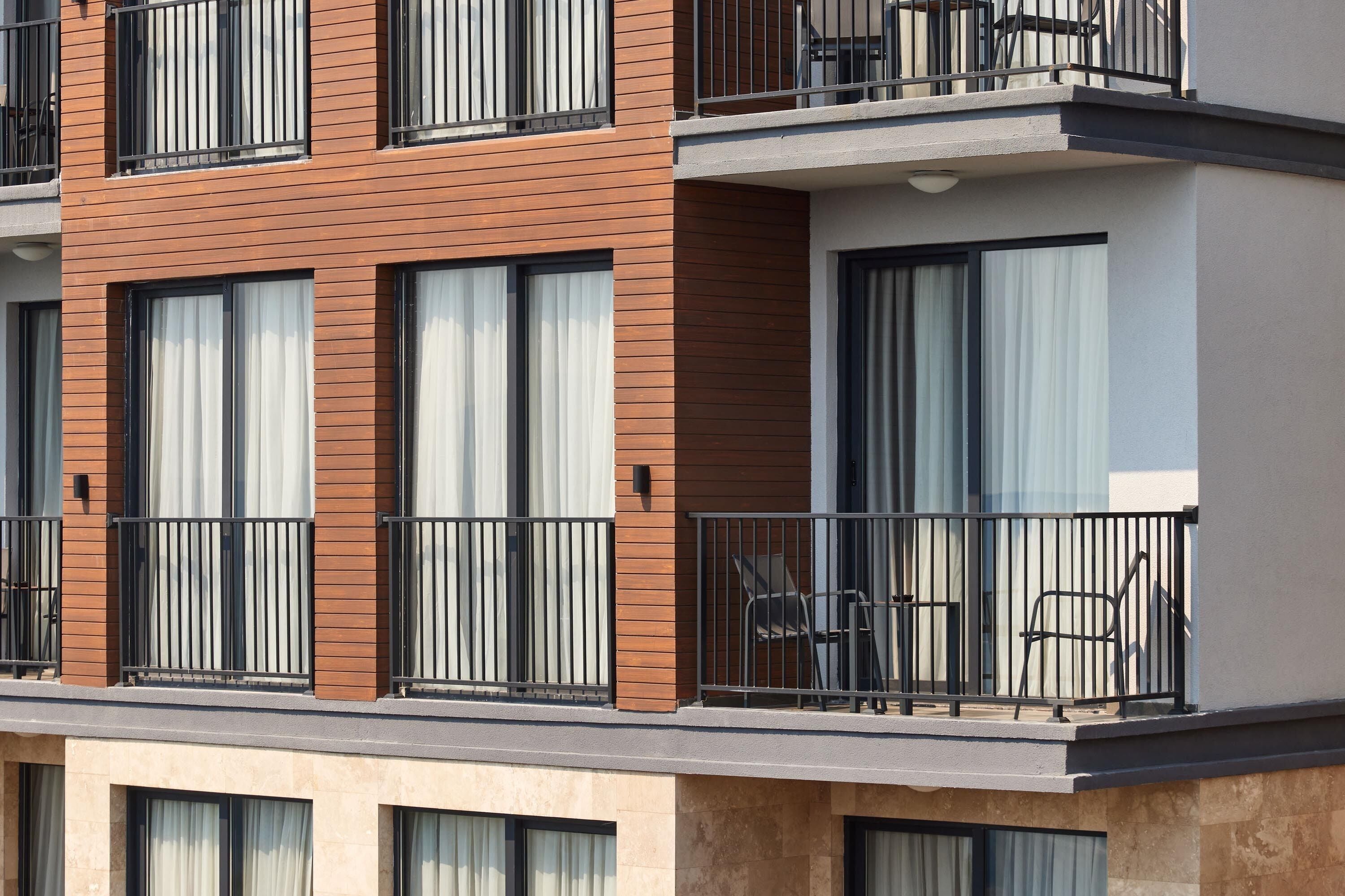 A multi-story building with balconies, large windows, and a modern architectural design.