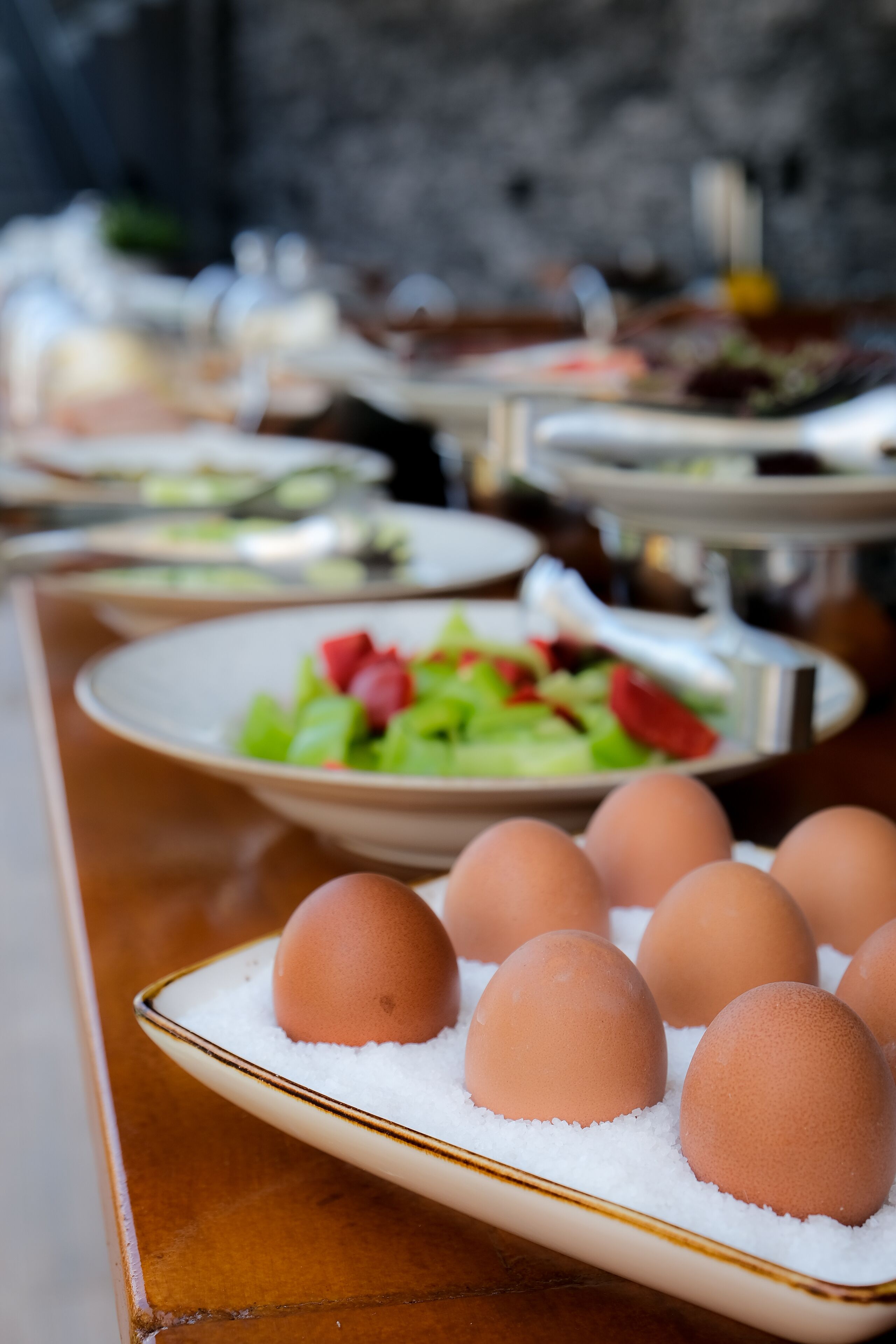 A table with plates of eggs and a salad.