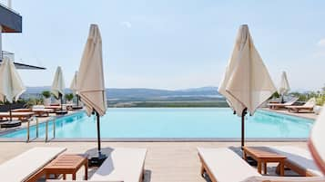 Una piscina al aire libre de temporada, sombrillas