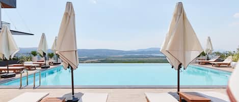 Una piscina al aire libre de temporada, sombrillas