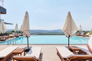 Una piscina al aire libre de temporada, sombrillas