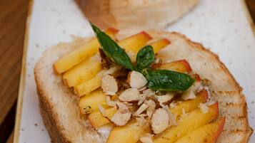 Dos rebanadas de tostada cubiertas de fruta y nueces sobre un plato blanco.