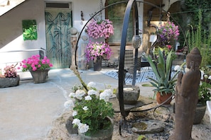 Un jardín con plantas en macetas y una estatua.