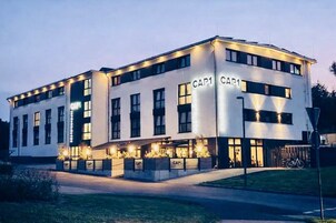 Un edificio moderno con señalización "CAP1", que presenta un techo plano, grandes ventanales y una zona de entrada bien iluminada.