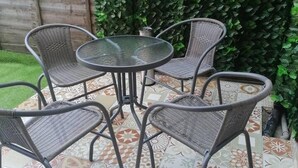 A patio with a round table and six wicker chairs. - Beach Apartment With Garden (Skegness)