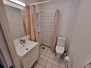 Un baño con lavabo, inodoro y zona de ducha.