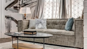 A living room with a sofa, a coffee table, and a lamp. - Contemporary Apartment - 5 Min To TIAA Bank Field! (Jacksonville)