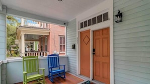 A porch with two chairs, a door, and a window. - Contemporary Apartment - 5 Min To TIAA Bank Field! (Jacksonville)