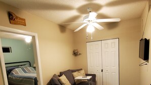 A compact living space with a ceiling fan, a sofa, a small table, a bench, and a door. - "the Sweet", close to downtown, beaches, parks, colleges, airports & hospitals. (Jacksonville)