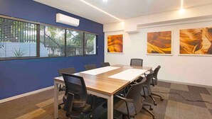 A conference room with a long table, chairs, a window with blinds, and three framed pictures on the wall. - Central Rosebank Unit (Johannesburg)