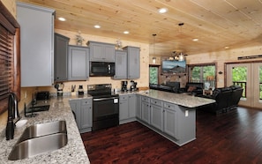 A spacious kitchen with granite countertops, stainless steel appliances, and a large island.