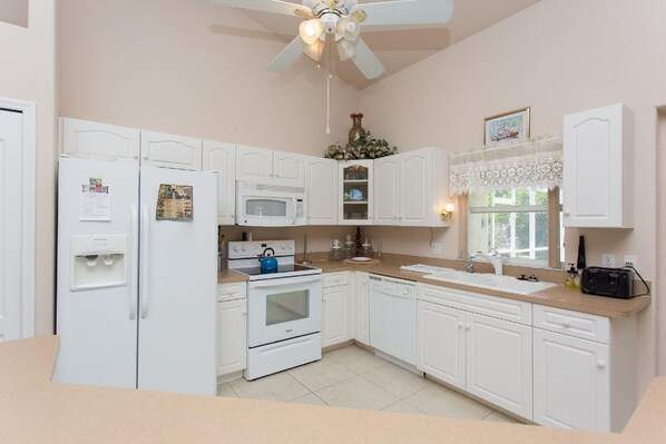 Fully equipped kitchen with refrigerator, microwave, stove, and dishwasher.