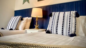 A hotel room with a bed, two pillows, a nightstand, a lamp, and wall decorations including stars and a sign. - Remarkable 3-bed Hot Tub House in Blackpool (Blackpool)