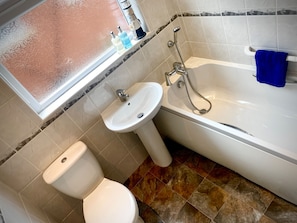 A bathroom with a toilet, sink, and bathtub. - Remarkable 3-bed Hot Tub House in Blackpool (Blackpool)