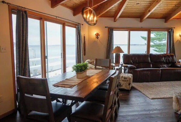 Relax in this inviting living space with a high ceiling, dining table, and comfortable sofa.