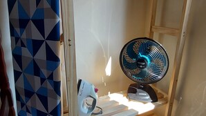 Letto a castello in legno con ventilatore integrato e stendibiancheria.
