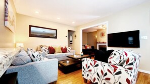 A modern living room with a sofa set, a coffee table, and a patterned armchair.