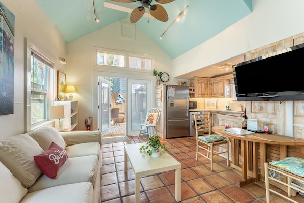 A spacious living area with a sofa, a coffee table, and a television.
