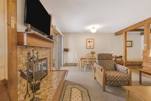 Cozy living room with a fireplace, television, and dining area.