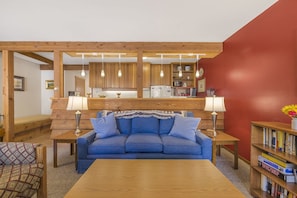 Relax in this inviting living room with a sofa set, coffee table, and bookshelf.