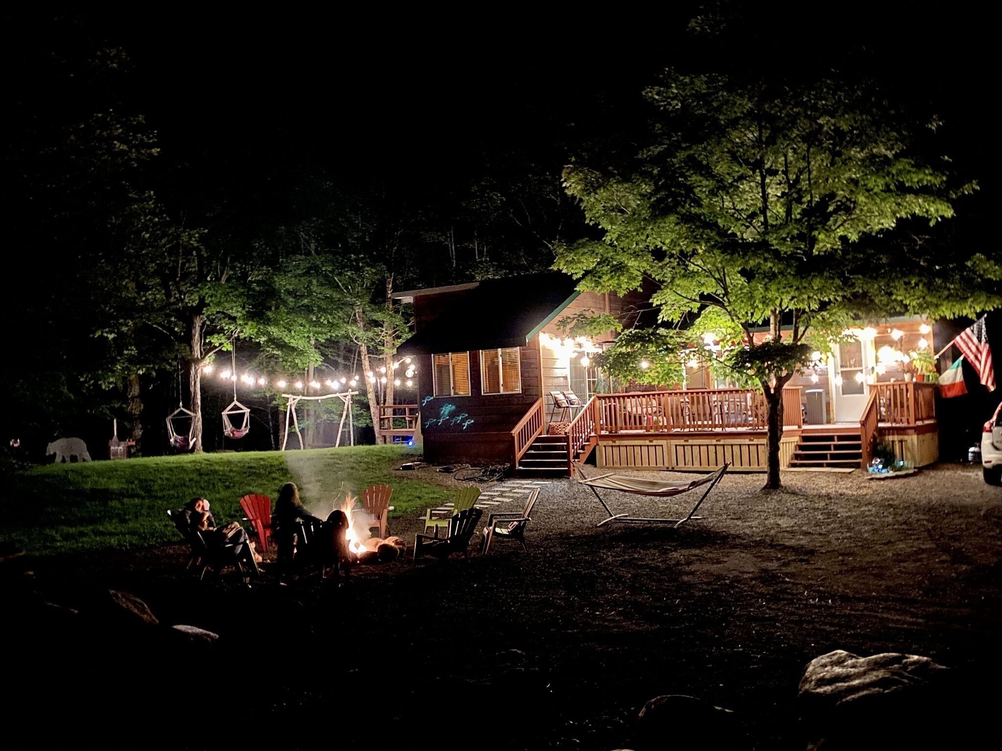 Une cabane dotée d’une terrasse, d’un espace salon extérieur et d’un foyer.
