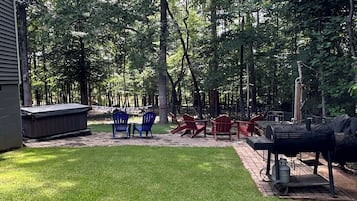 Ein Garten mit Whirlpool, Gartenmöbeln und Grill.