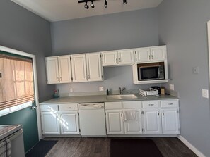 A kitchen with white cabinets, a microwave, and a dishwasher. - The Paradise @ Lyncott, A famiily friendly place to stay! (Lansing)