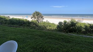 Een grasveld met uitzicht op het strand en de oceaan.