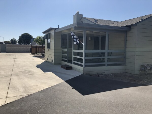 A single-story house with a covered porch, a garage, and a fenced backyard.