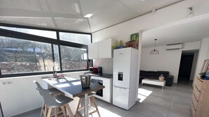 A modern kitchen with a large island, bar stools, and a refrigerator. - Villa Avec Jacuzzi la Cadiere Dazur (La Cadière-d'Azur)