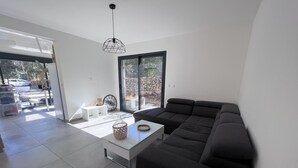 A modern living room with a sectional sofa, a coffee table, and a pendant light. - Villa Avec Jacuzzi la Cadiere Dazur (La Cadière-d'Azur)