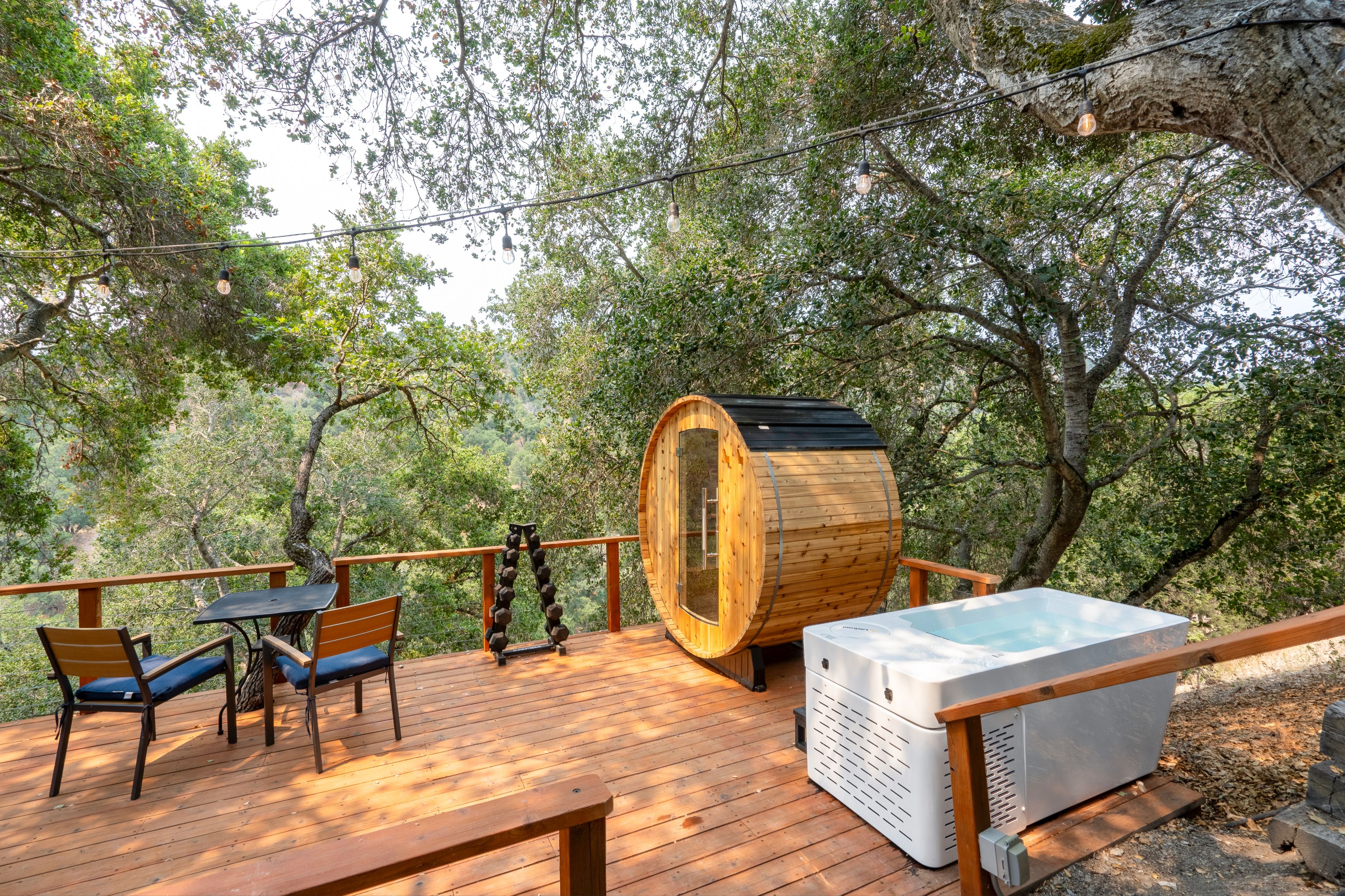 Eine Holzterrasse mit Gartenmöbeln, einer Sauna und einer Holzbottlei.