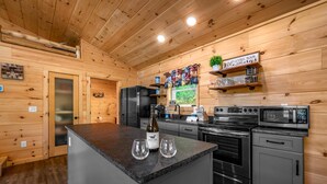Una cocina moderna con paredes de madera, encimera de granito y electrodomésticos de acero inoxidable.