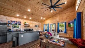 Un interior de cabaña espacioso con cocina, comedor y una sala de estar acogedora.