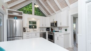 Una cocina moderna con armarios blancos, electrodomésticos de acero inoxidable y una isla grande.