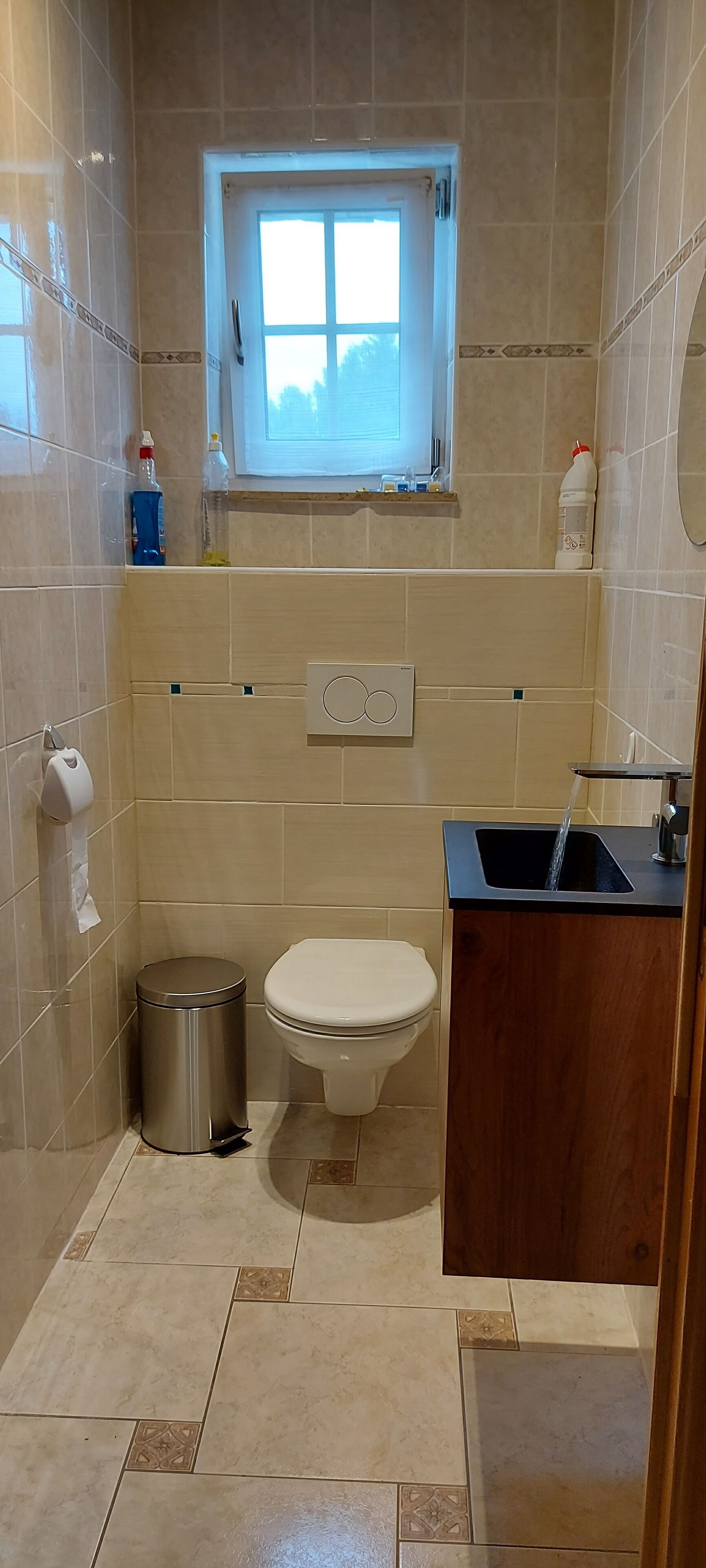 Ein Badezimmer mit Toilette, Waschbecken und Fenster.